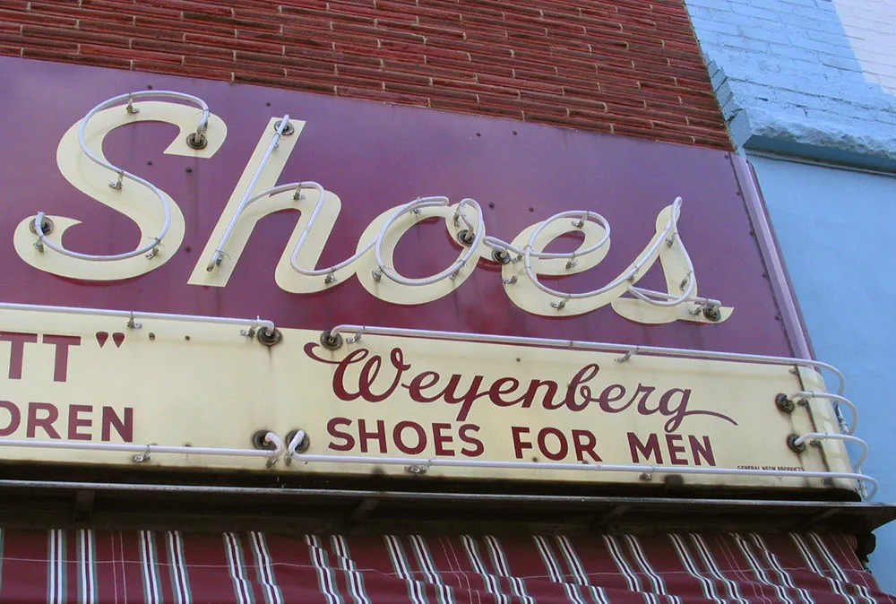 Photo of a hand-lettered metal/neon sign that says &#x27;Shoes&#x27;